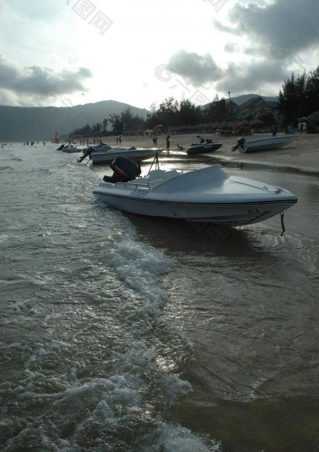 海滩落日下的摩托艇图片