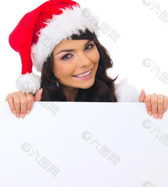 空白广告牌后面的圣诞漂亮美女图片