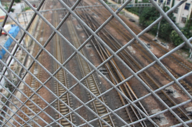 有铁丝网隔离的桥下的铁道