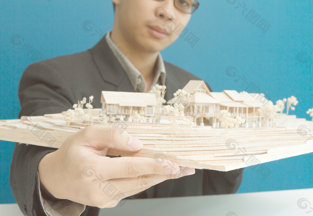 男人用他手中的房子模型