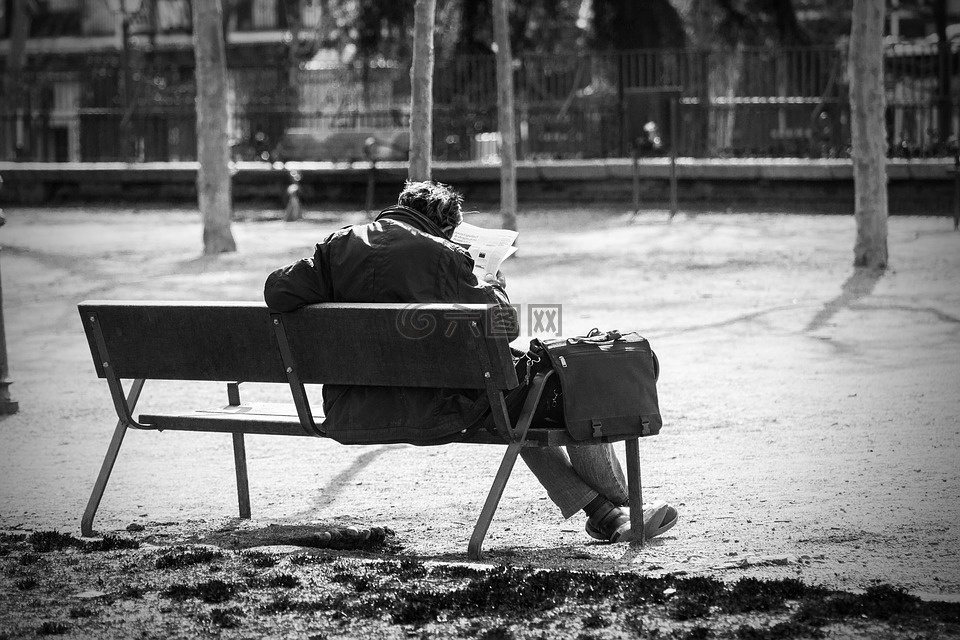 男子的长椅上,公园,看报纸