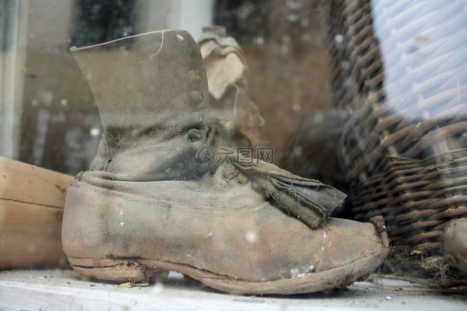 在窗口中的旧靴子,古代的鞋,旧的窗口显示