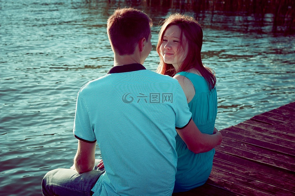 女孩与男孩,在池塘的岸边,由水