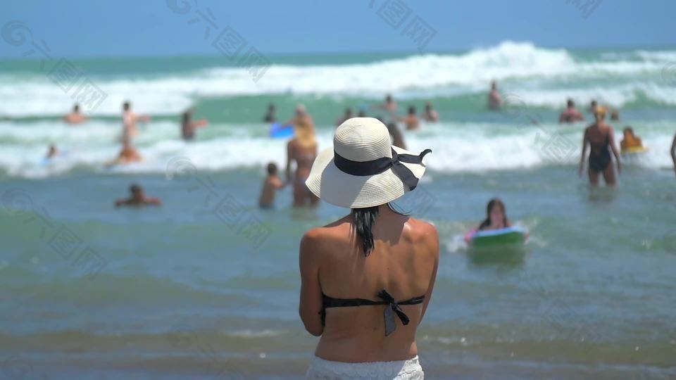 站在沙滩上戴着帽子的女人