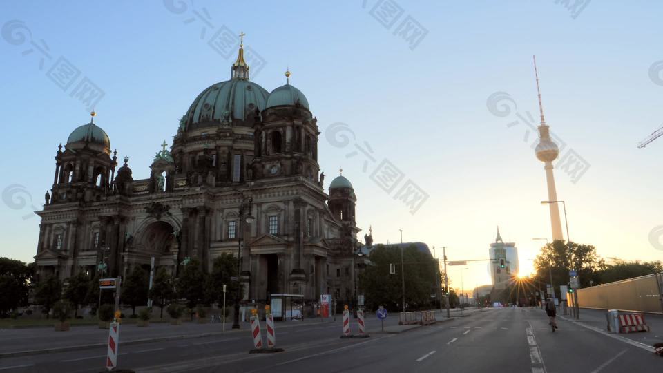 骑自行车的人在日出时路过柏林大教堂