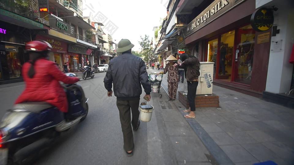 在越南街上用水桶走路的男人